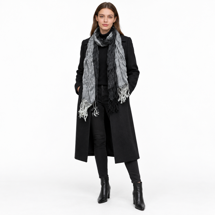 Adult woman wearing the jacquard scarf with a dark winter outfit, full body visible.