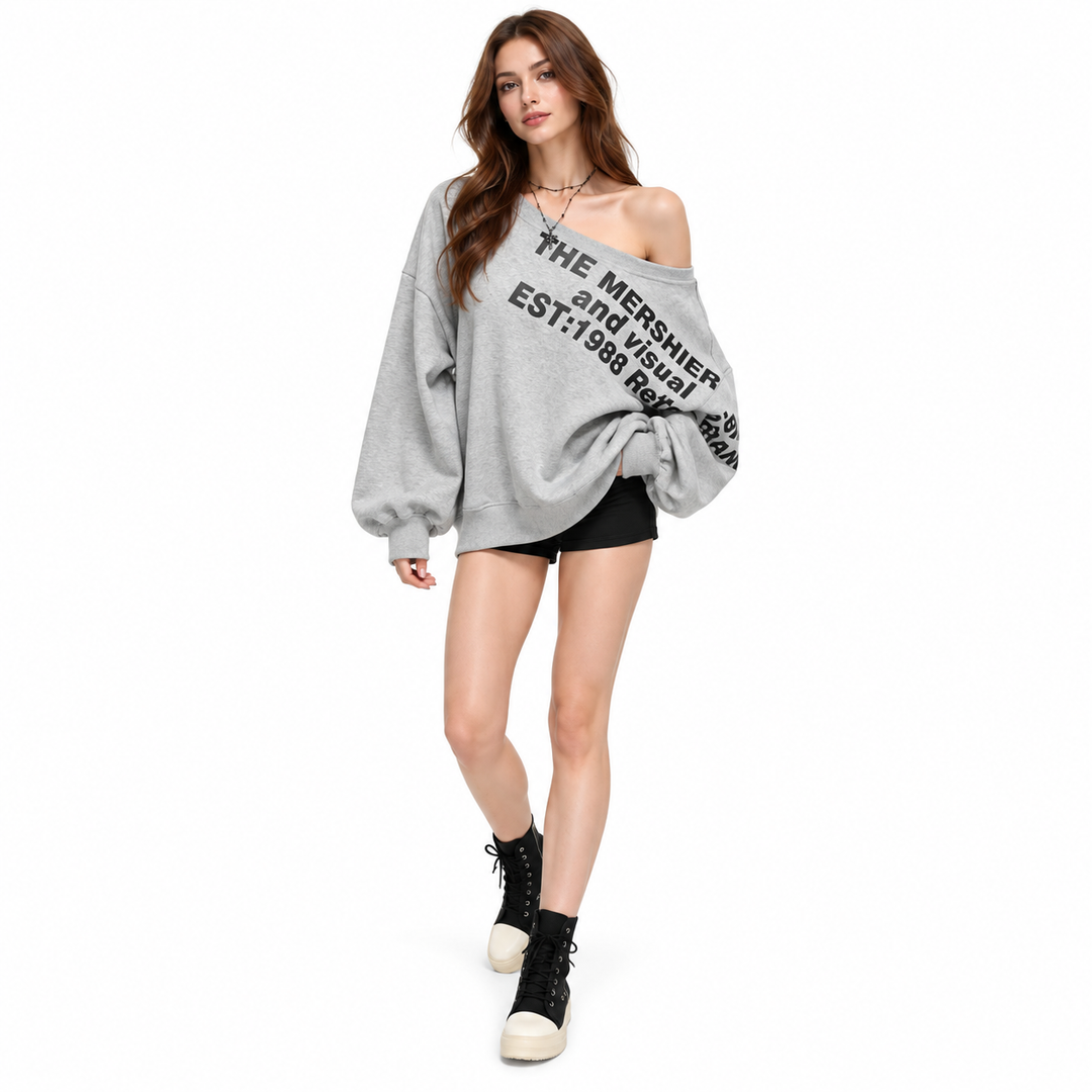 Three-quarter front view of a grey printed pullover on a model in mid-step, with black shorts and high-top shoes in a studio.