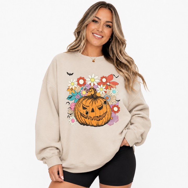 Woman wearing beige Halloween pumpkin floral sweatshirt with jack-o-lantern graphic on a clean white studio background.