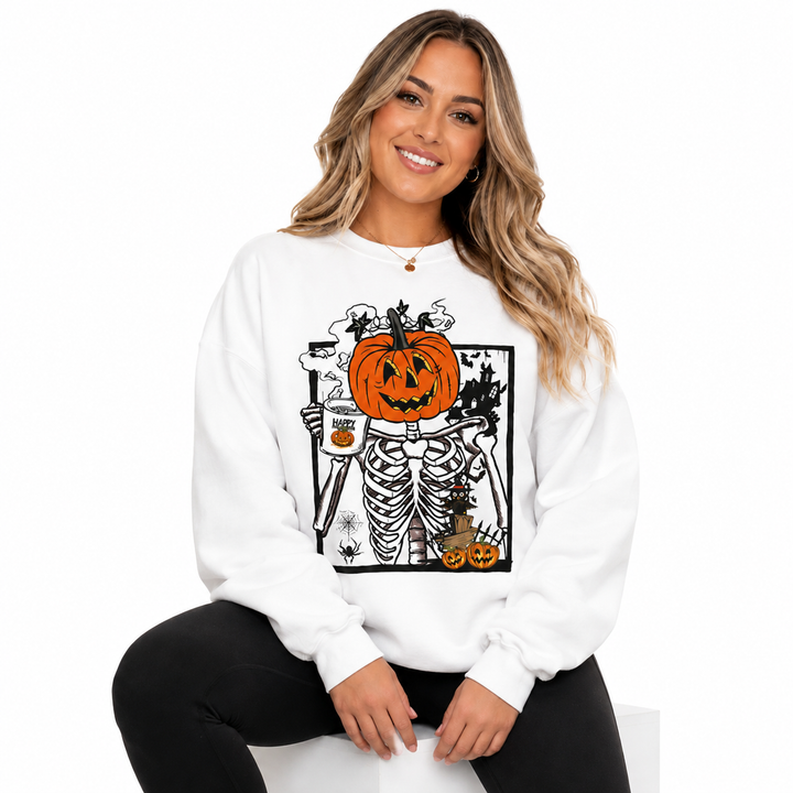 Woman seated in white Halloween pumpkin sweatshirt with pumpkin skeleton graphic on a clean white studio background.
