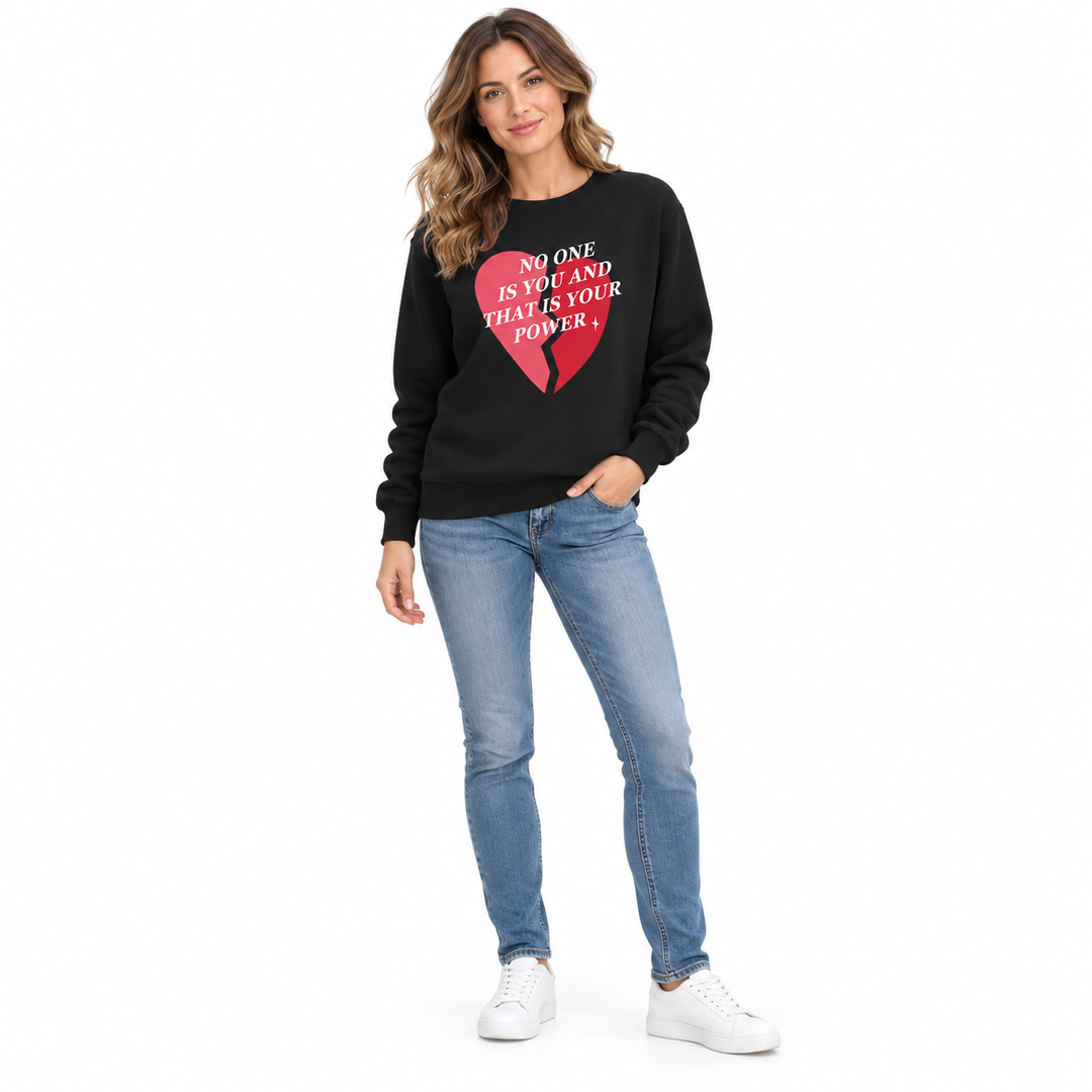 Black printed sweatshirt shown on a full-length female model in three-quarter pose, with blue jeans against a white backdrop.