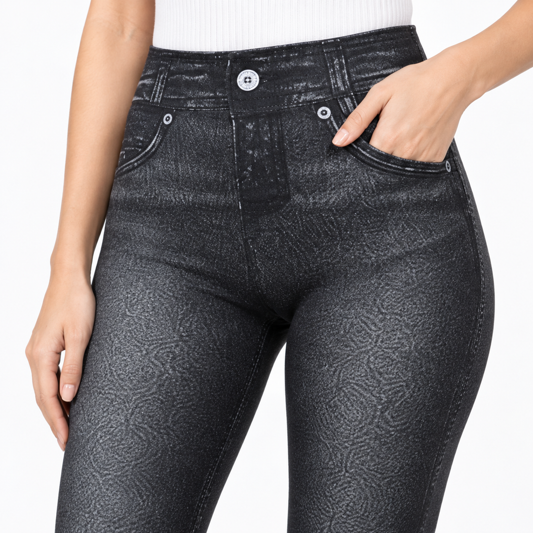 Black high waisted jeggings close-up showing the waistband, printed denim texture, faded shading and upper seam details.