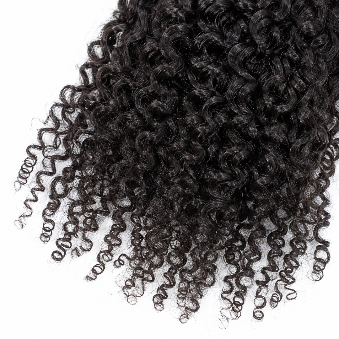 Close-up of natural-black curly hair strands and curled ends showing the wig texture against a plain white studio background.