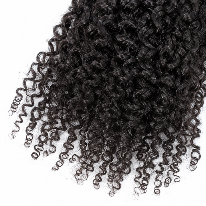 Close-up of natural-black curly hair strands and curled ends showing the wig texture against a plain white studio background.