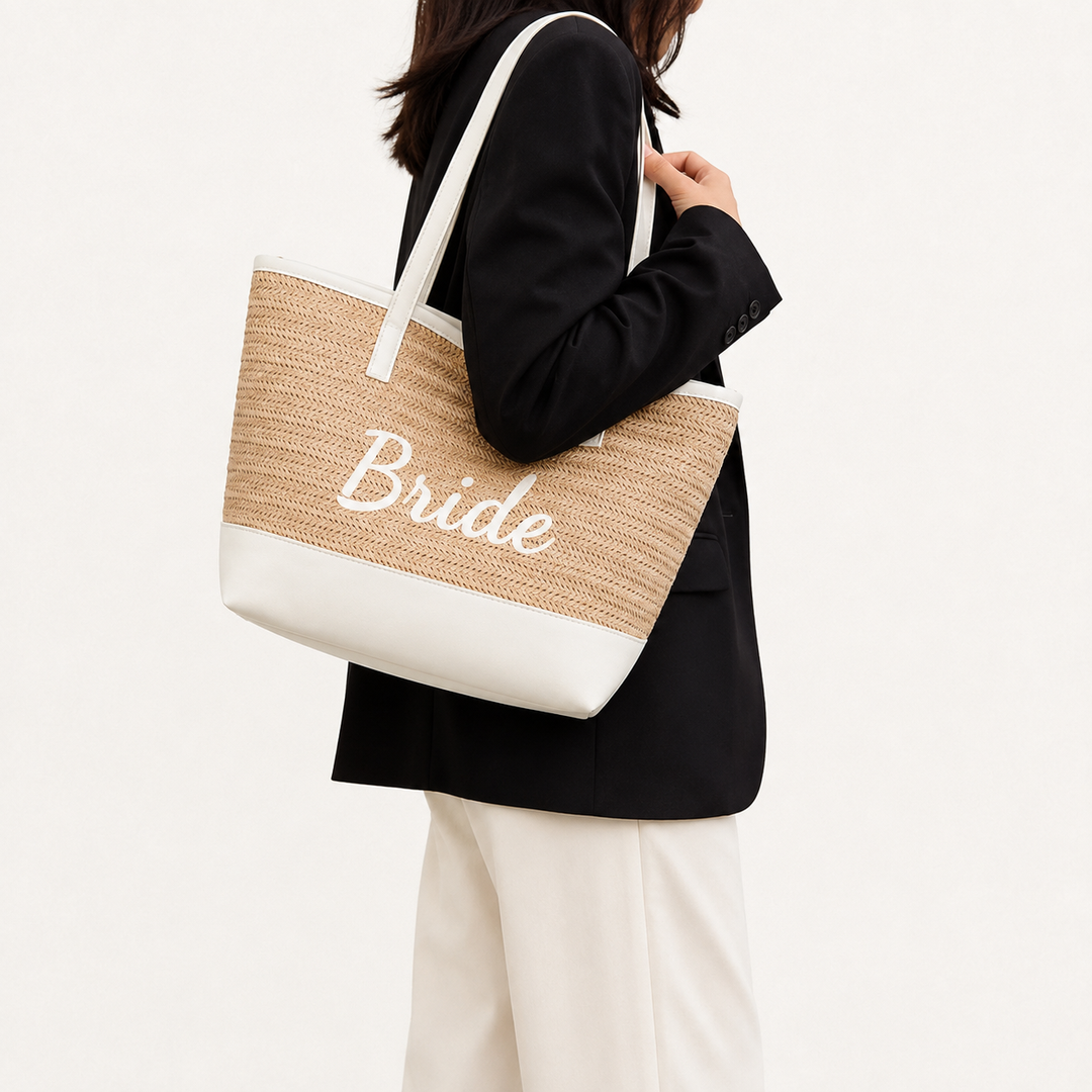 Side fit view of Bride woven beach tote carried over the shoulder, showing its proportions, light khaki body and white trim