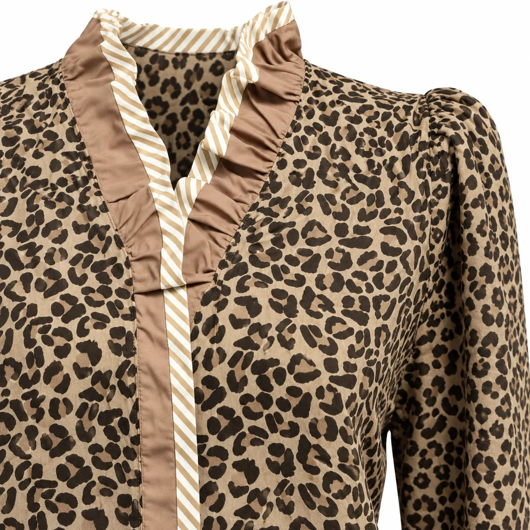 Close front view of the beige ruffle neckline, striped edging and tan leopard print on the Wild Leopard Elegance blouse style