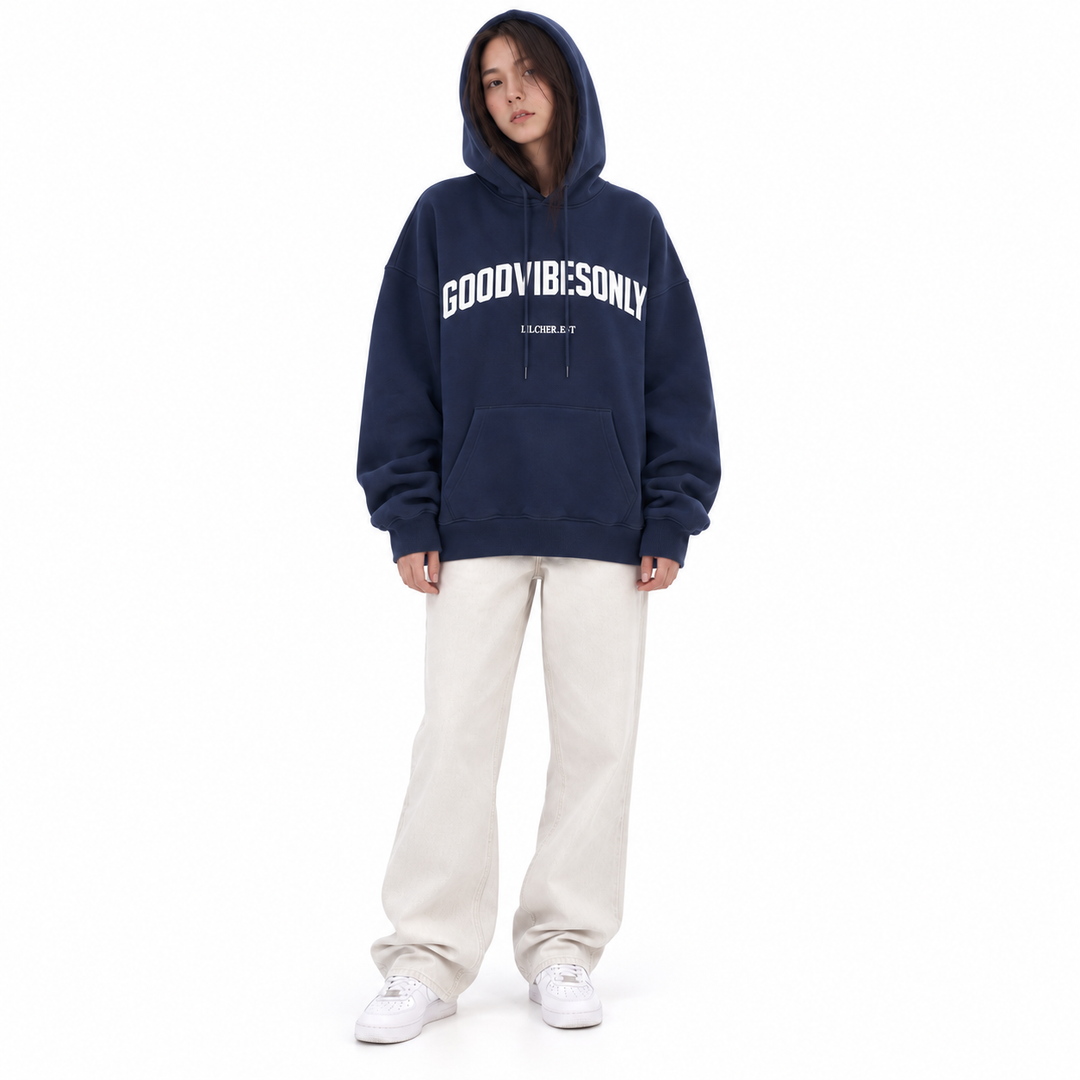 Navy blue hoodie worn with the hood raised, showing white chest lettering and front pocket on a full-body model against white
