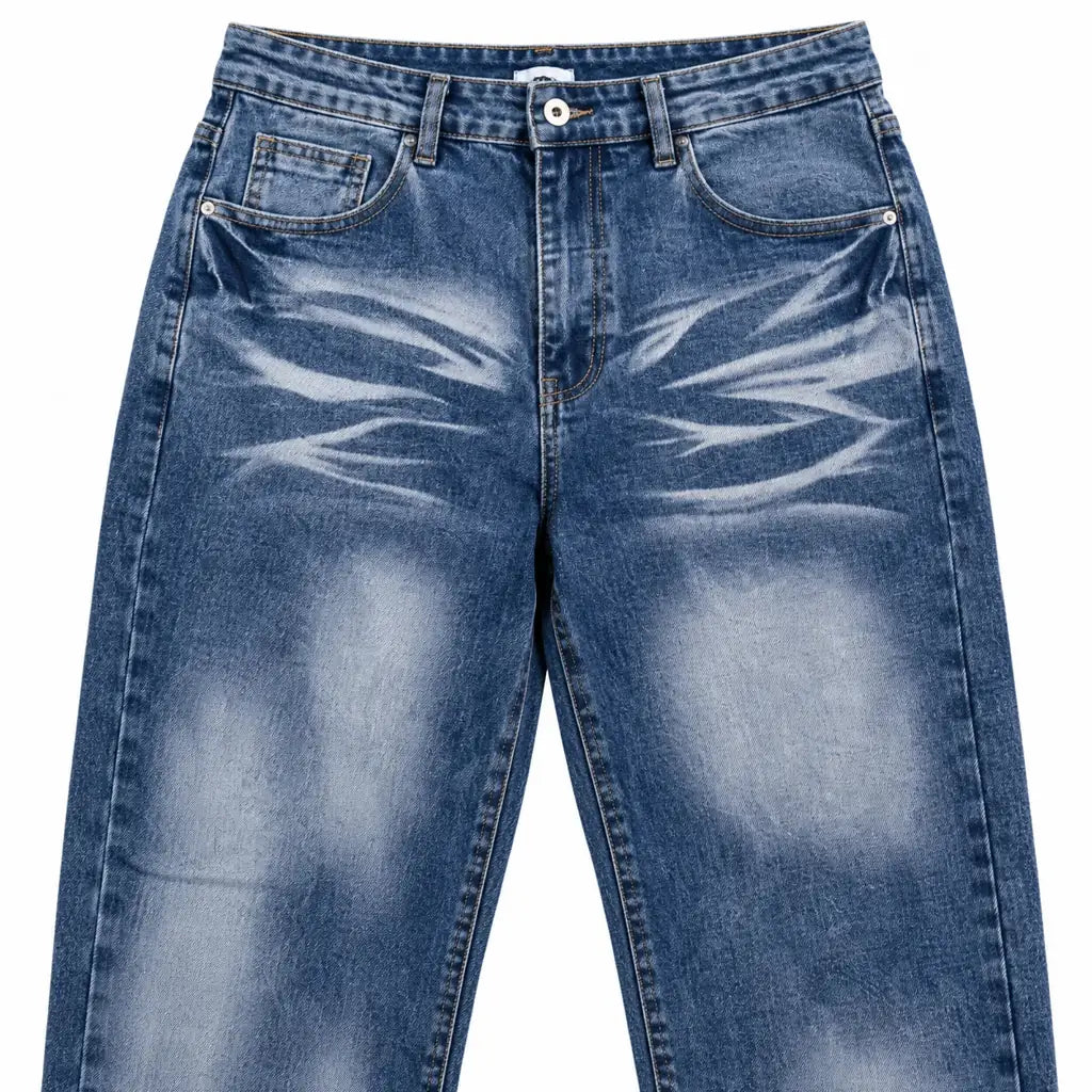Close-up of blue denim jeans showing front waistband, coin pocket, rivets, stitching, faded thighs and curved whisker design.