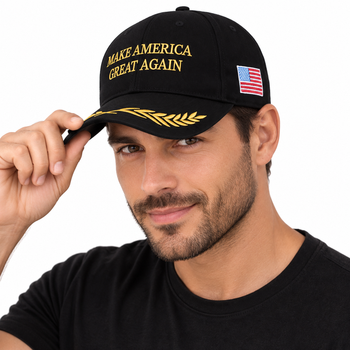 Male model wearing a black cap with gold front embroidery, gold brim detail and a US flag side patch.