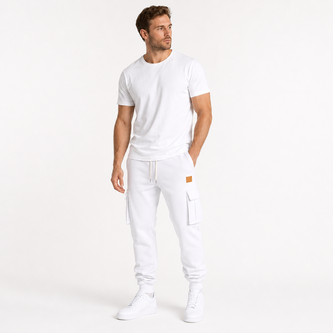 Male model wearing white cargo jogger pants in a minimalist lifestyle pose on a clean white studio background.