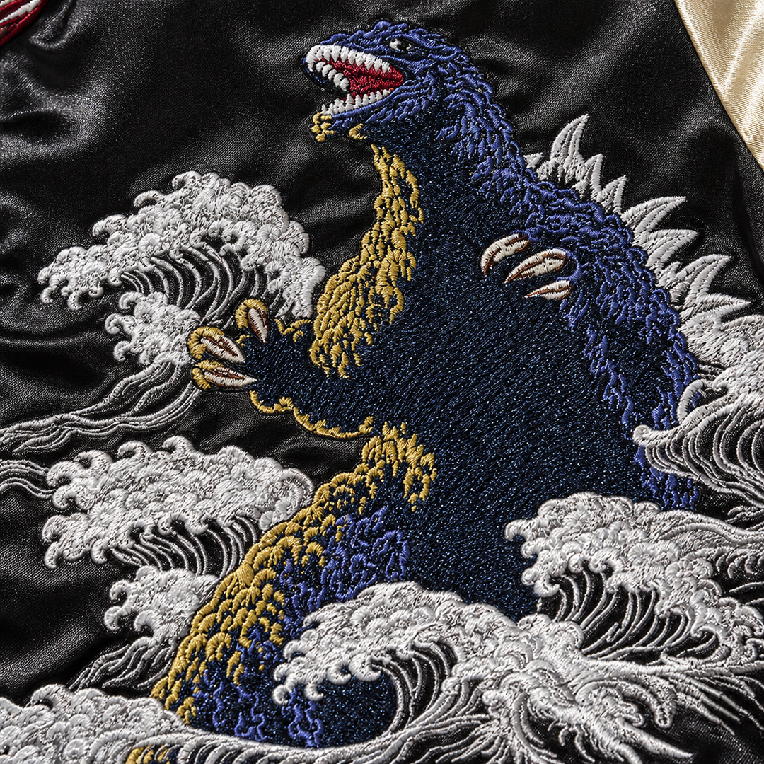 Close-up of embroidered creature and wave detail on the black body of the men&