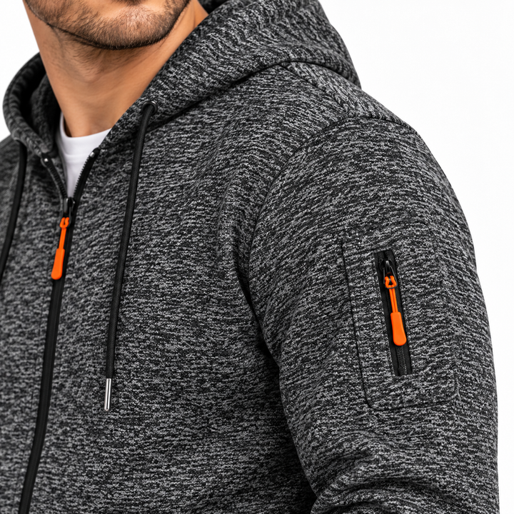Close-up of Dark Gray fleece sweater sleeve showing zip pocket, orange pull, stitching, seam placement and marled texture now