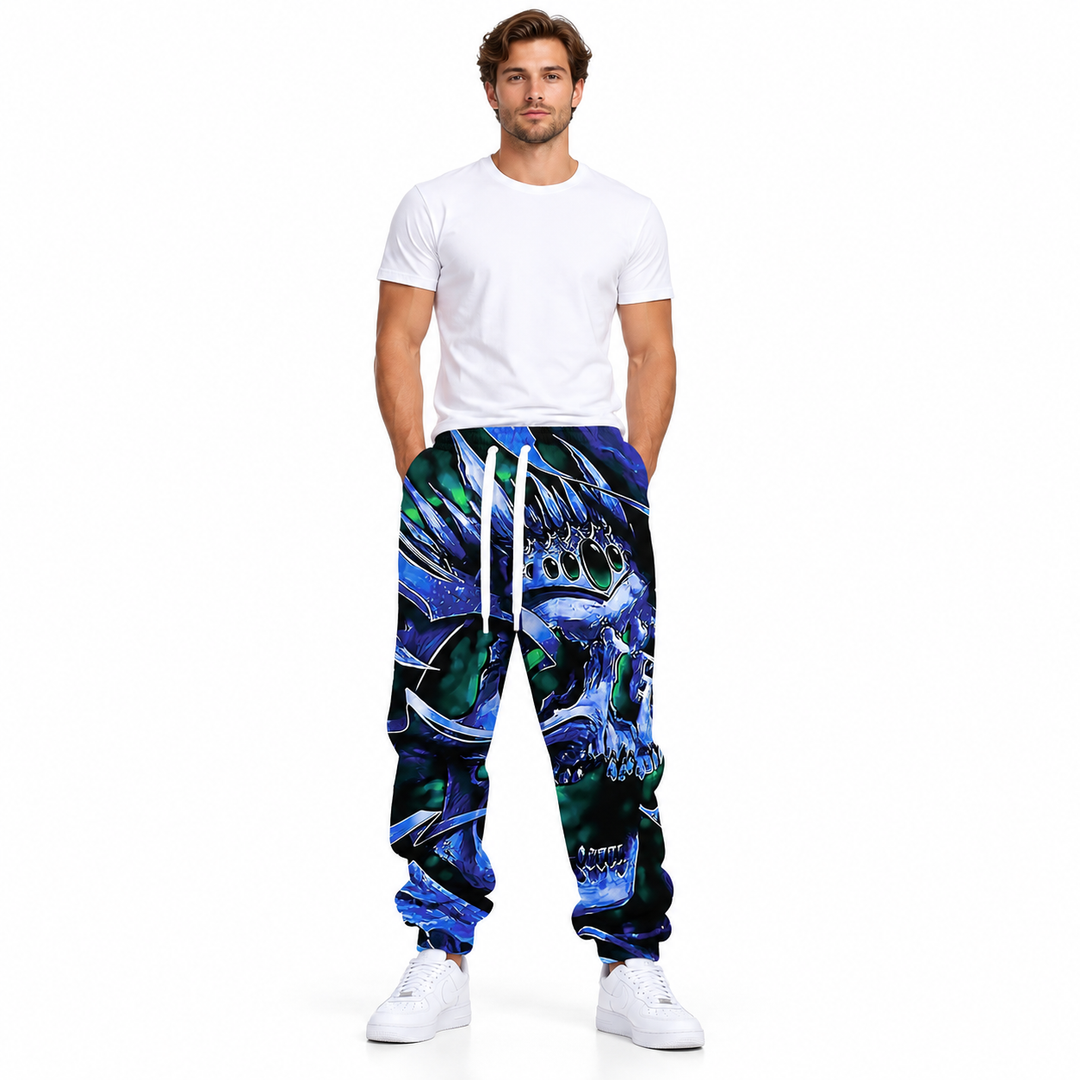 Male model wearing blue crown skull print joggers with a white drawstring, plain white tee and sneakers on a white background