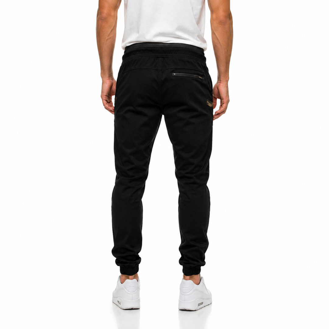 Black slim jogger pants for men shown from the back with tapered legs, rear zip pocket and everyday casual styling front view