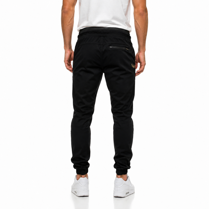 Black slim jogger pants for men shown from the back with tapered legs, rear zip pocket and everyday casual styling front view