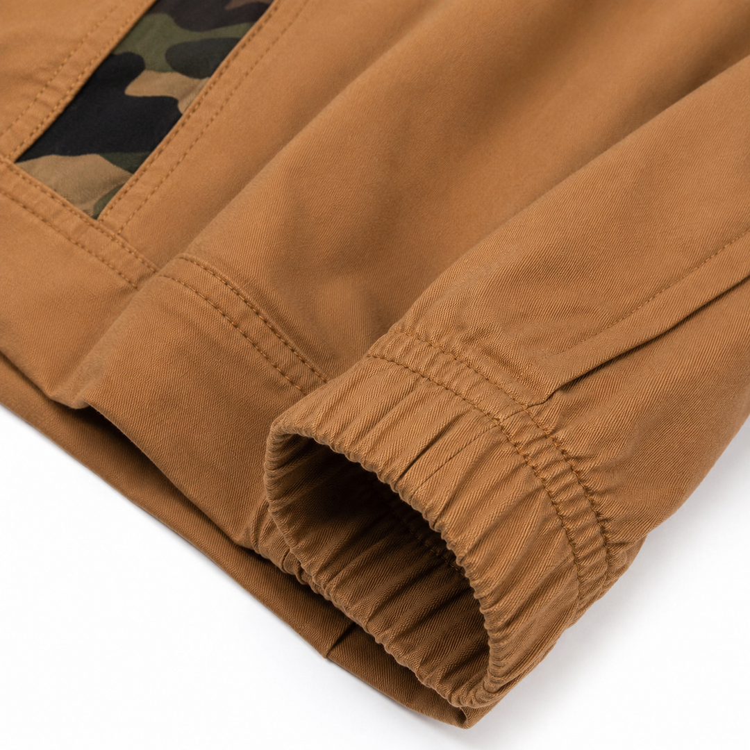 Khaki jogger pants close-up showing cotton blend fabric texture, stitching, elastic cuff and camouflage pocket trim in detail