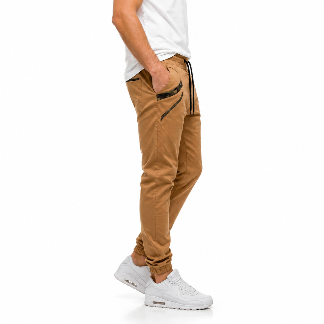 Khaki slim jogger pants for men shown from the side with tapered leg shape, elastic cuff and camouflage pocket trim in detail