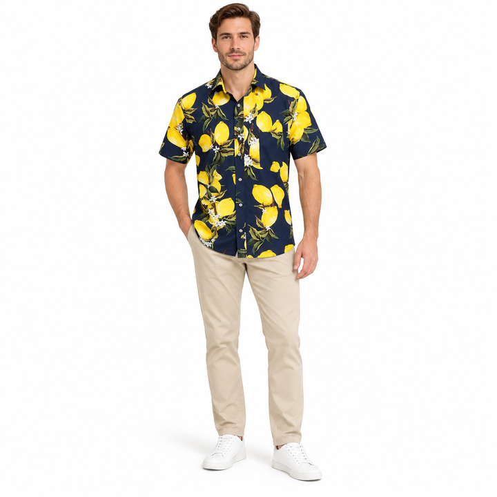 Model wearing a navy fruit print shirt in a full-body front view with trousers and shoes visible on a plain white background.
