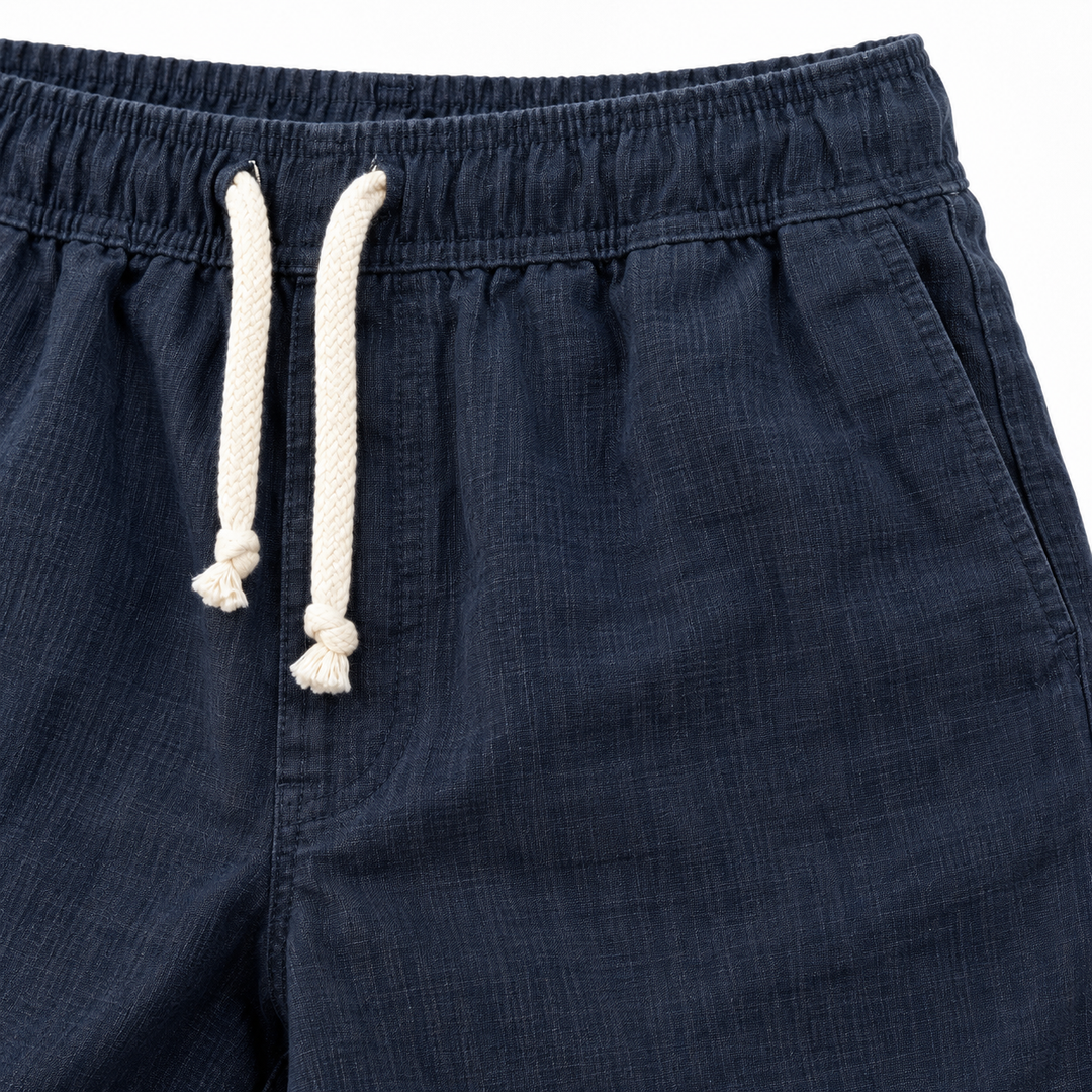 Close-up of navy drawstring shorts waistband, stitching and woven texture