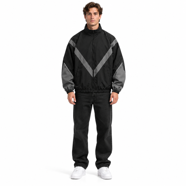 Front view of a male model in the black and gray style 6618 jacket with stand collar, chevron panels and front zip, on white.