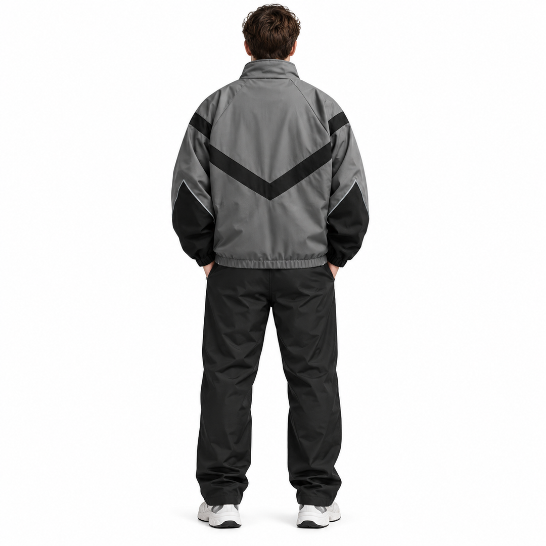 Back view of a male model wearing the gray with black style 6618 jacket with a V-shaped panel, gathered hem and long sleeves.