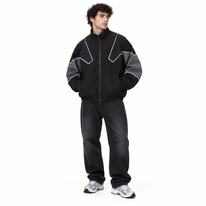 Male model in the black and gray style 6657 jacket with angular piping, front zip and contrasting sleeves, shown full length.