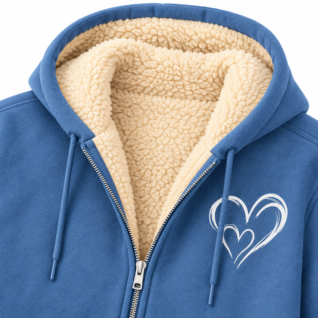 Close-up of dusty blue sherpa-lined zip hoodie showing lining, zipper and heart graphic.