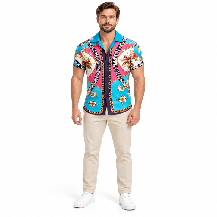 Adult male model shown wearing the turquoise multicolor ornamental shirt in beige trousers and white shoes in a white studio.