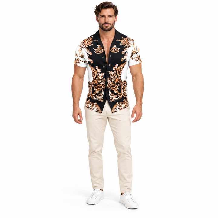 Male model shown wearing the white black and gold scroll collared shirt with beige trousers and white sneakers against white.