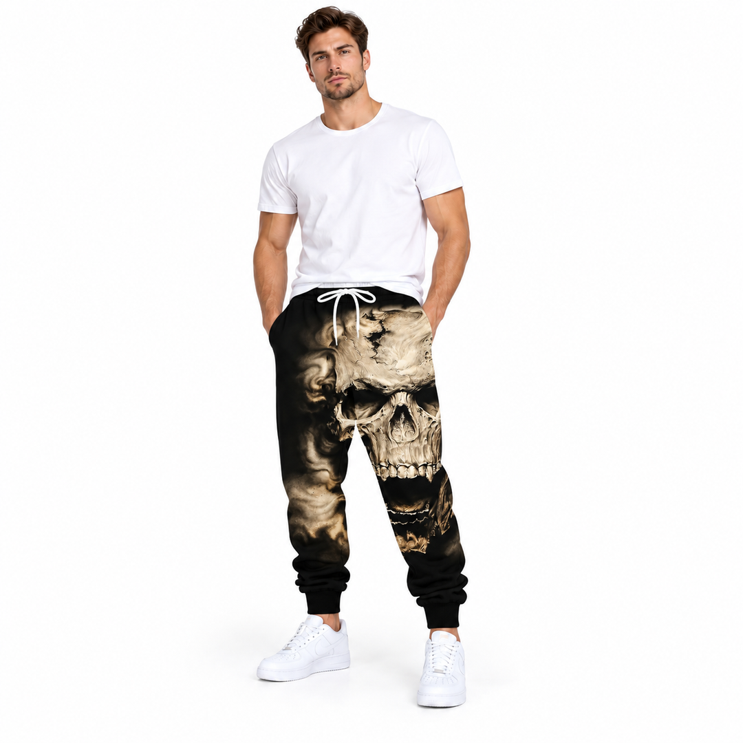 Male model wearing beige skull drawstring pants, with a plain white T-shirt and white sneakers, on a white studio background.