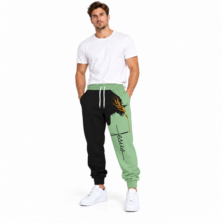 Male model wearing green Jesus print drawstring pants, with a plain white tee and white sneakers, in a full-body studio view.