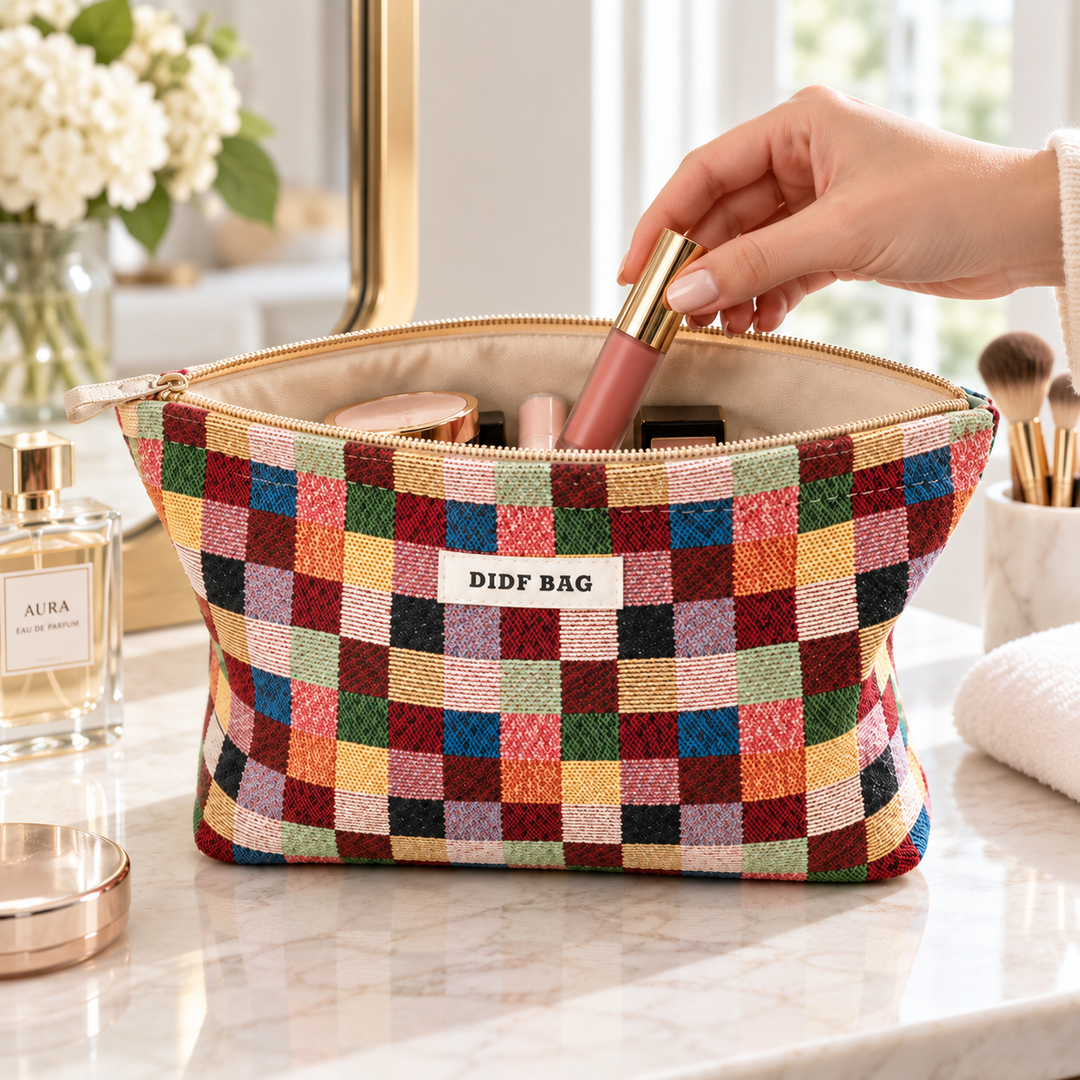 Multicolor Plaid makeup bag open on a vanity while a lipstick is placed inside for everyday cosmetic storage.