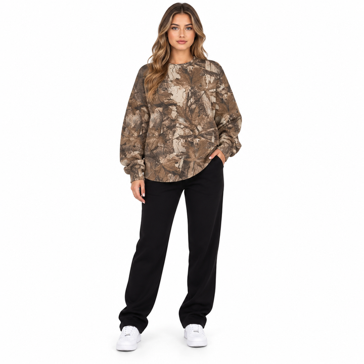 Woman in a dark brown branch print sweatshirt shown from the front with the printed design visible in a white studio setting.