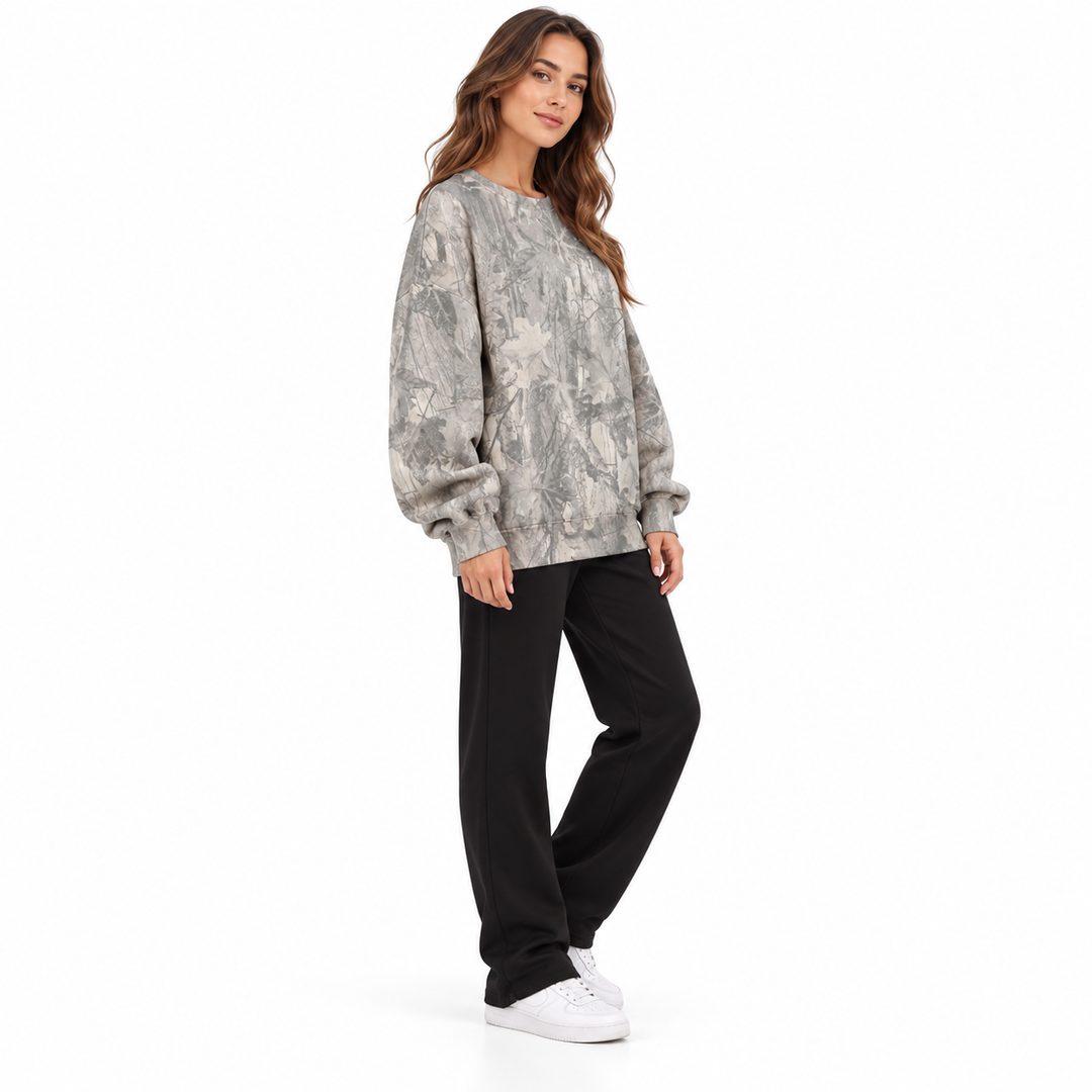 Model wearing a grey branch print sweatshirt shown from the side with the garment design visible on a plain white background.