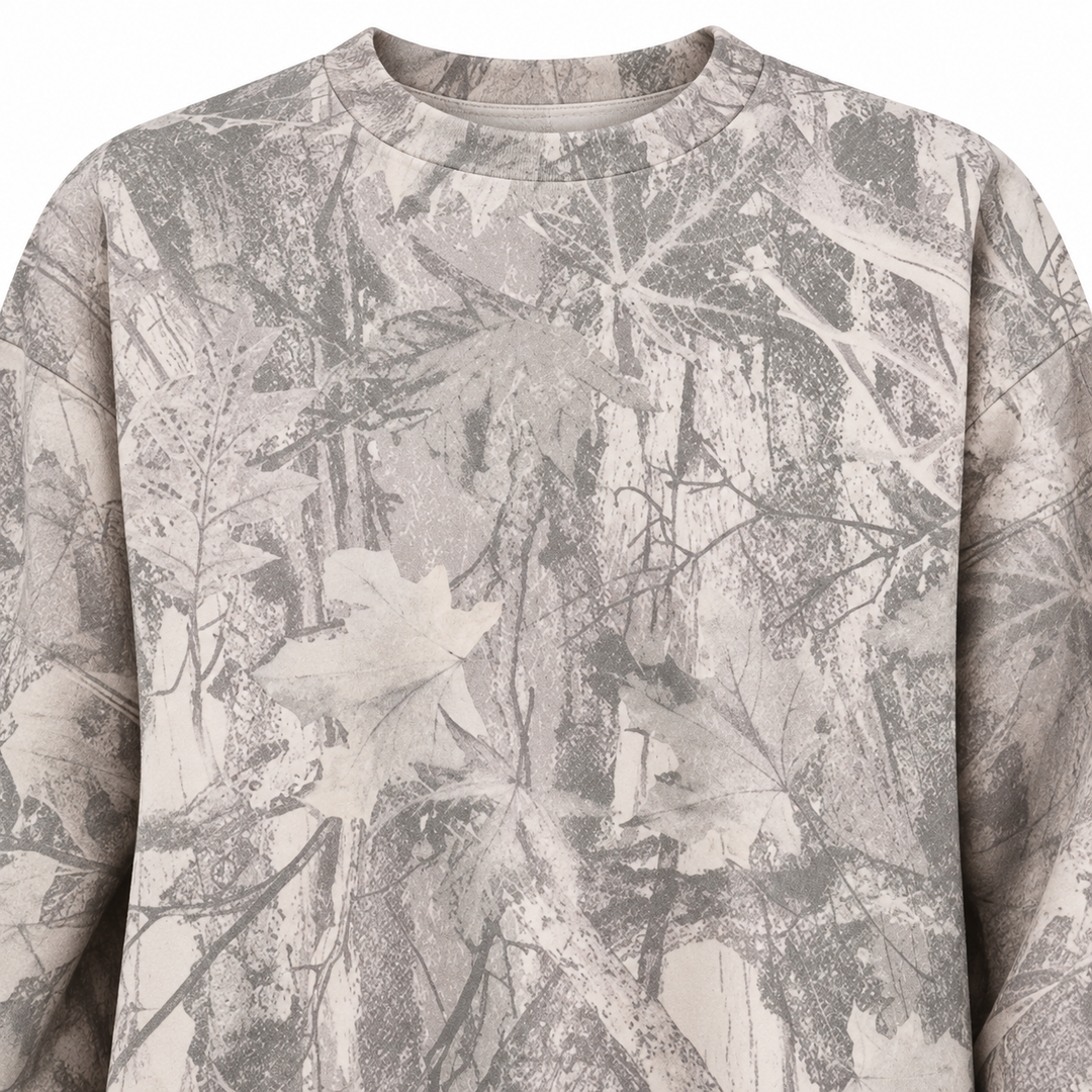 Close-up of the grey sweatshirt front, showing the branch and leaf print on the chest with the garment surface fully visible.