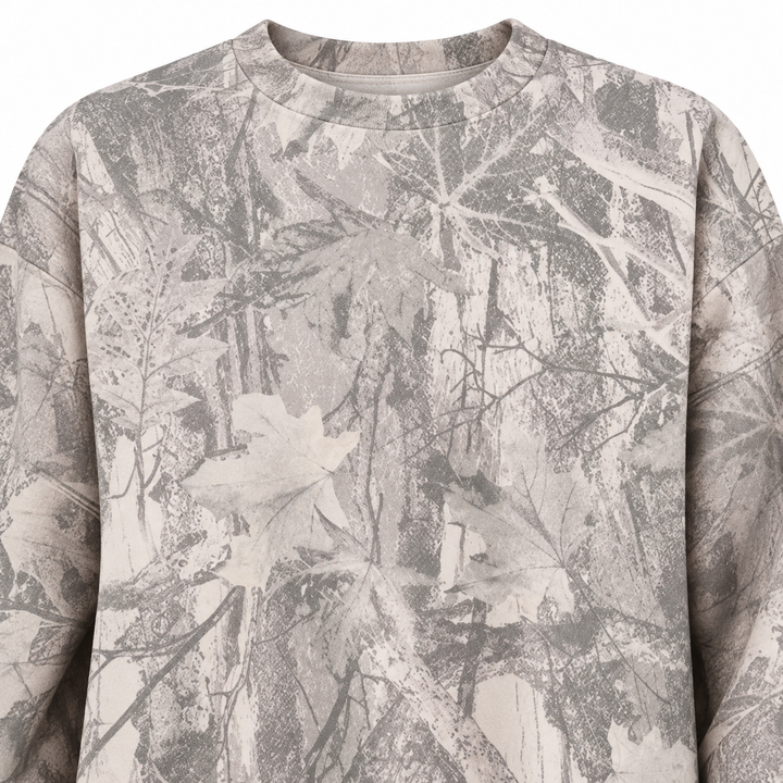Close-up of the grey sweatshirt front, showing the branch and leaf print on the chest with the garment surface fully visible.