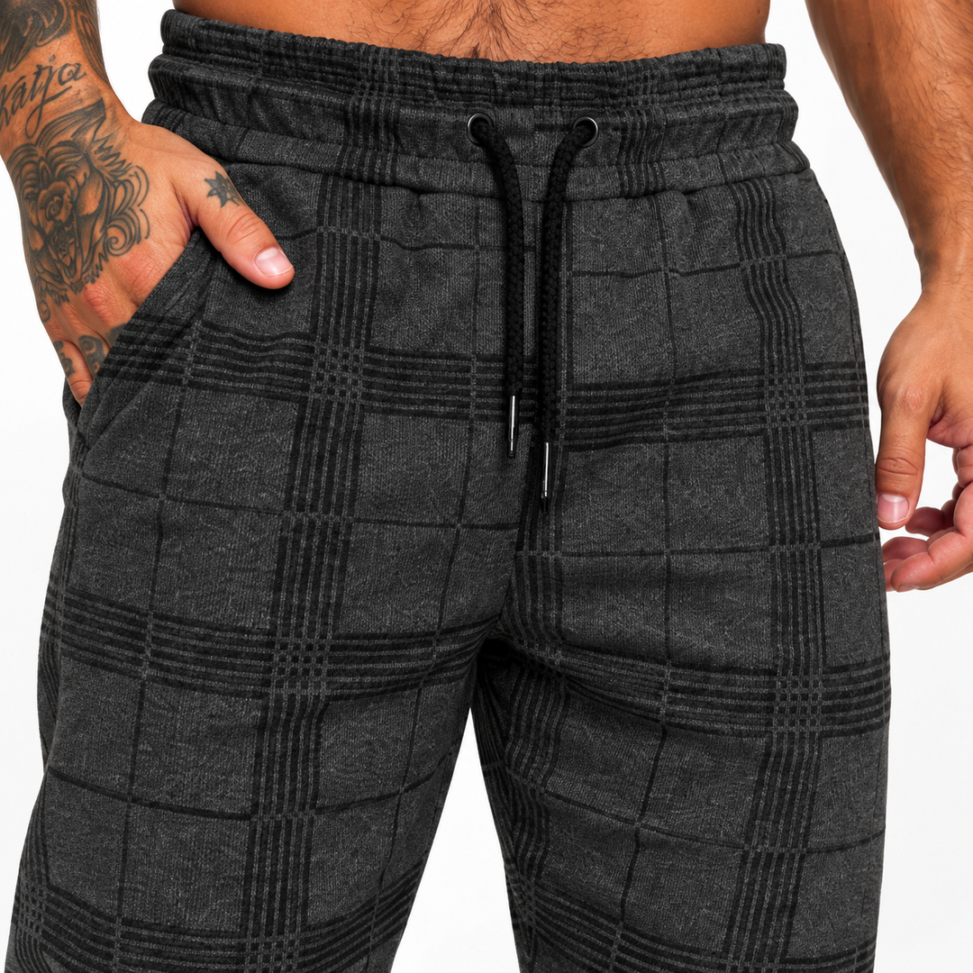 Dark grey plaid jogger pants macro detail with elastic waist, black drawstring, check pattern, side pocket and fabric texture