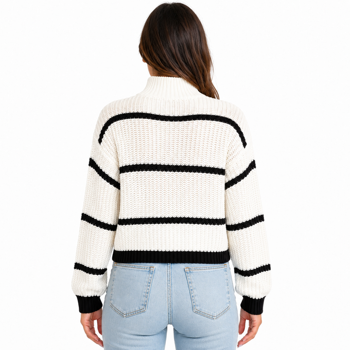 White striped mock-neck sweater shown from the back on a model with visible black stripes, ribbed cuffs, hem, and knit texture.