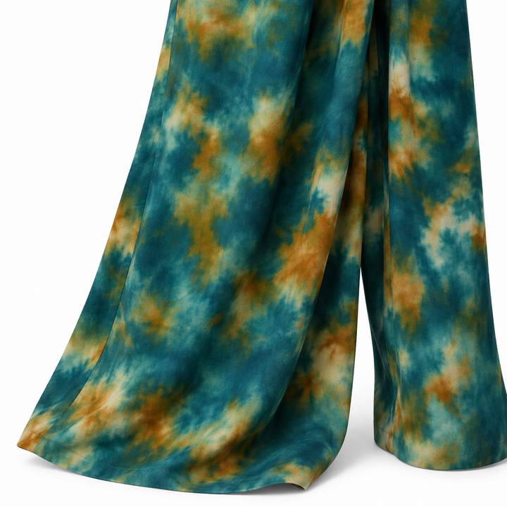 Close-up of teal green, ochre and cream tie-dye print on the wide-leg fabric