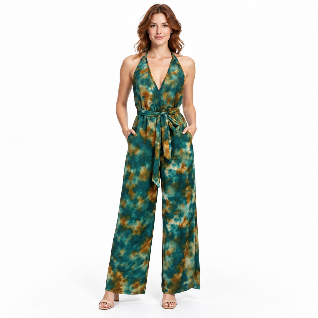 Front view of halter jumpsuit on an auburn-haired model with hands in the side pockets