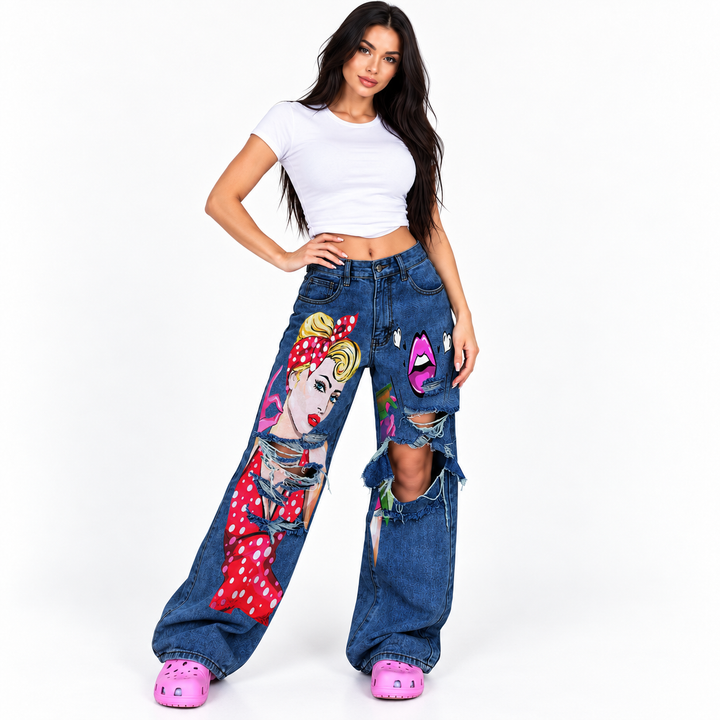 Commercial hero view of dark blue distressed art print wide leg jeans on a model against a clean studio background.