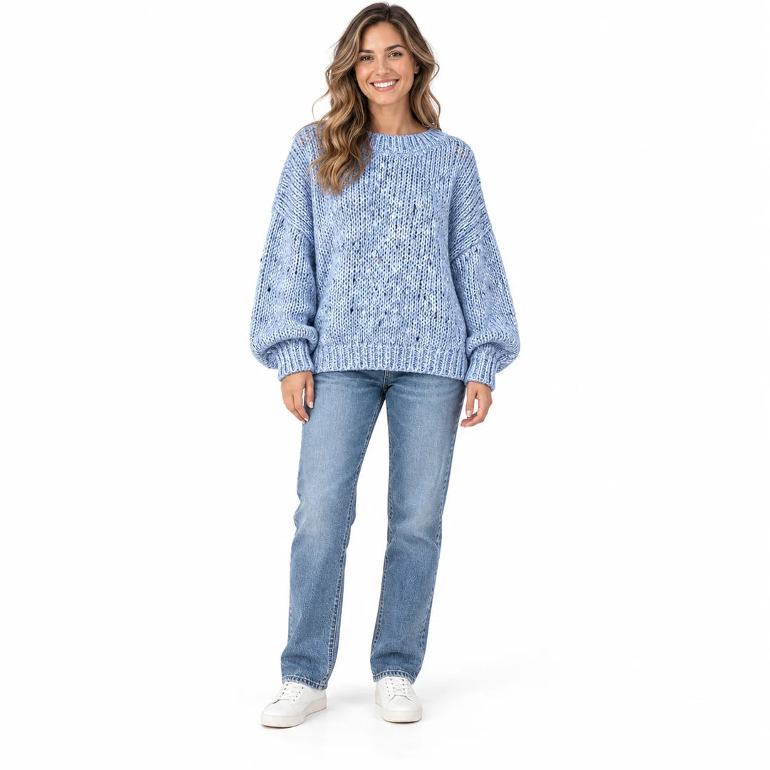 Powder Blue polka dot sweater on a full-length female model, with a ribbed neckline, relaxed sleeves and ribbed hem on white.