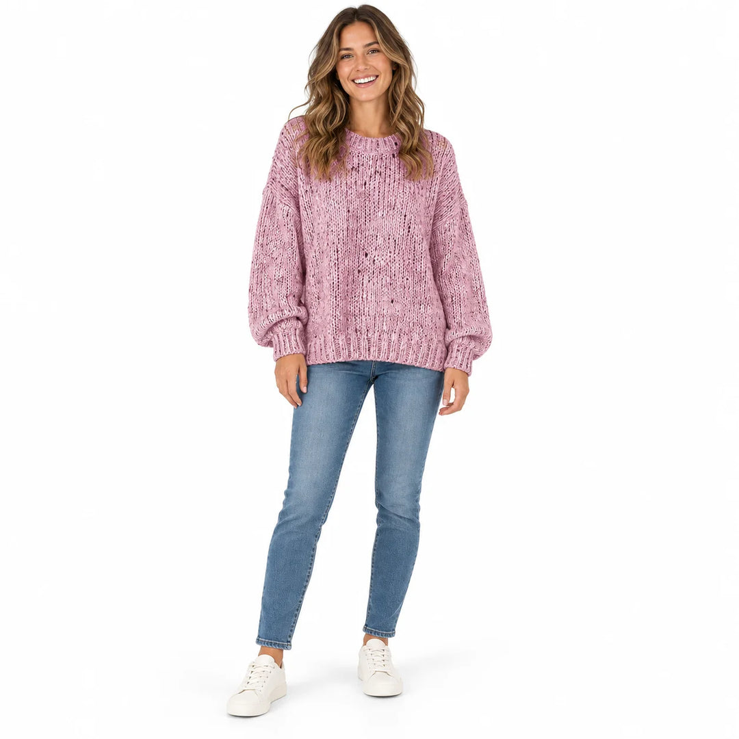 Dusty Pink polka dot sweater on a full-length female model, showing a ribbed neckline, long loose sleeves and its ribbed hem.