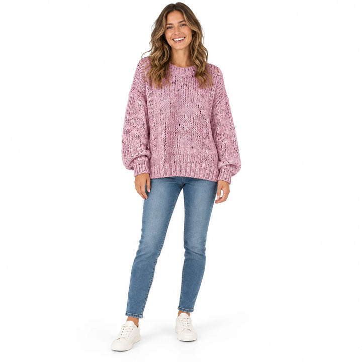Dusty Pink polka dot sweater on a full-length female model, showing a ribbed neckline, long loose sleeves and its ribbed hem.