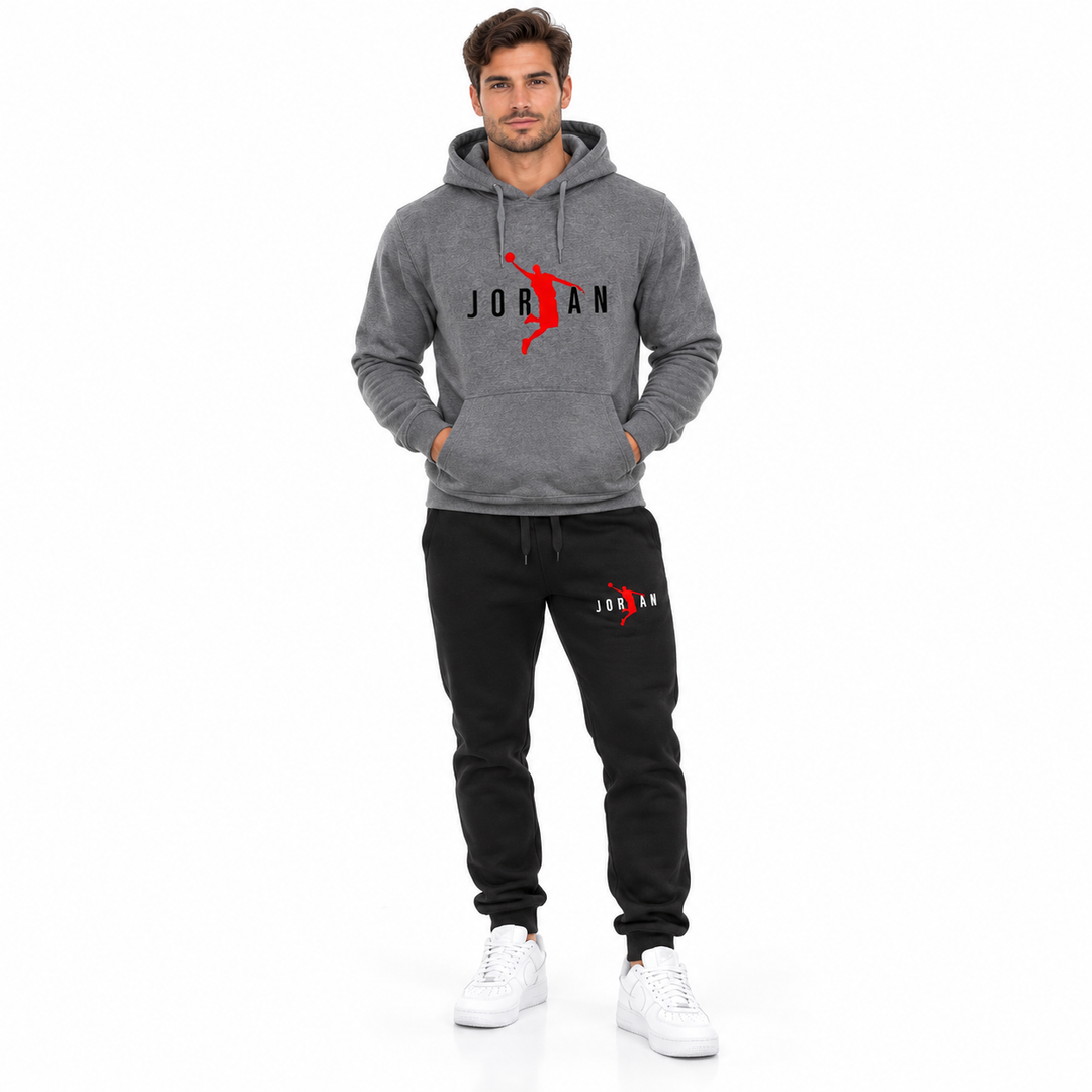 Male model wearing the dark grey / black lettering hoodie and black pants set on a white studio background.