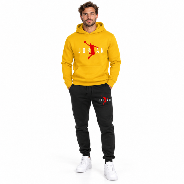 Male model wearing the yellow / white lettering hoodie and black pants set on a white studio background.