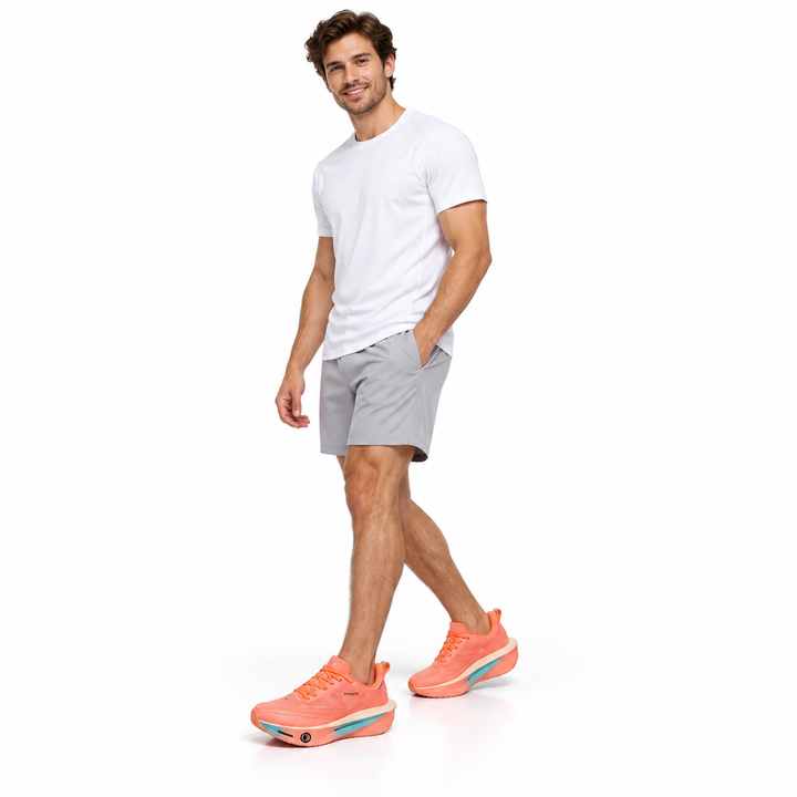Male model wearing coral pink lace-up sneakers on a white studio background.
