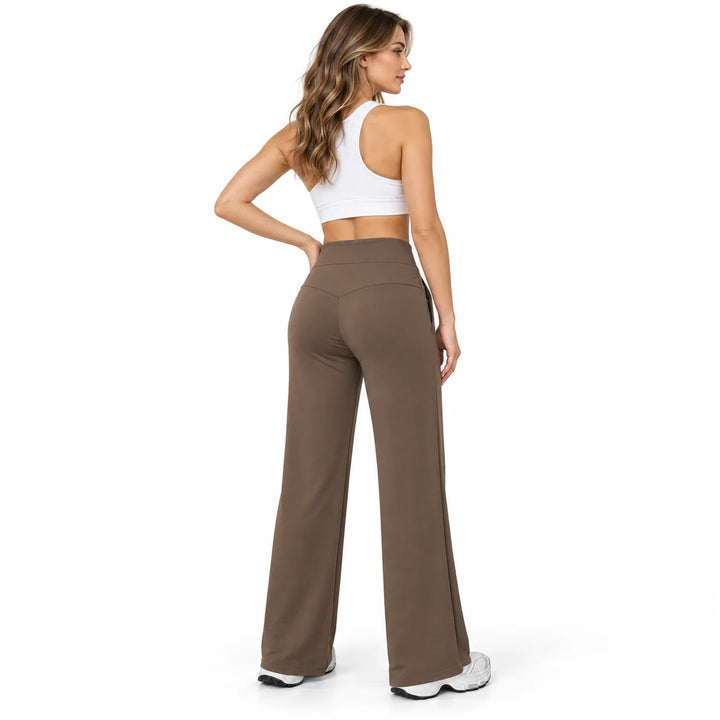 Rear view of coffee brown athletic trousers on a full-body model, showing a curved yoke seam and long straight legs in studio