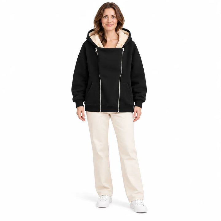 Heavyweight zip up hoodie in Black on a full-body female model, with cream hood lining, twin front zippers and front pockets.