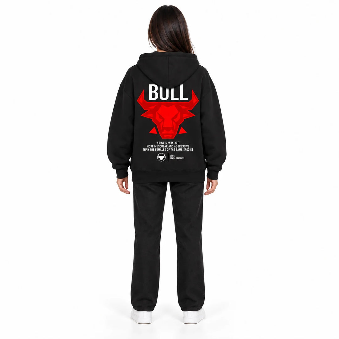 Unisex graphic hoodie in black with a red bull back print, shown on a full-body female model against a white studio backdrop.